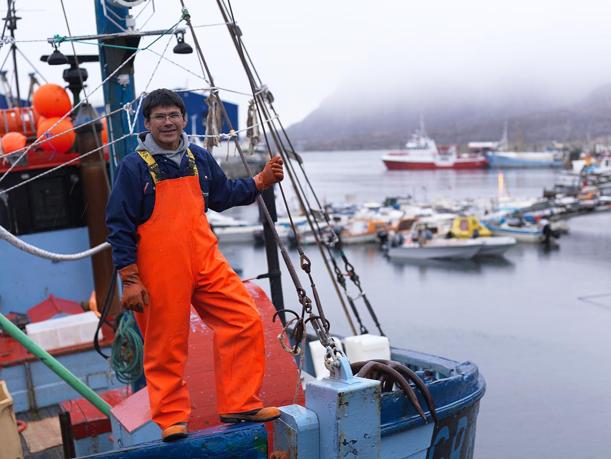 Un pescatore di Sisimiut in Groenlandia fotografato sulla sua barca nel porto